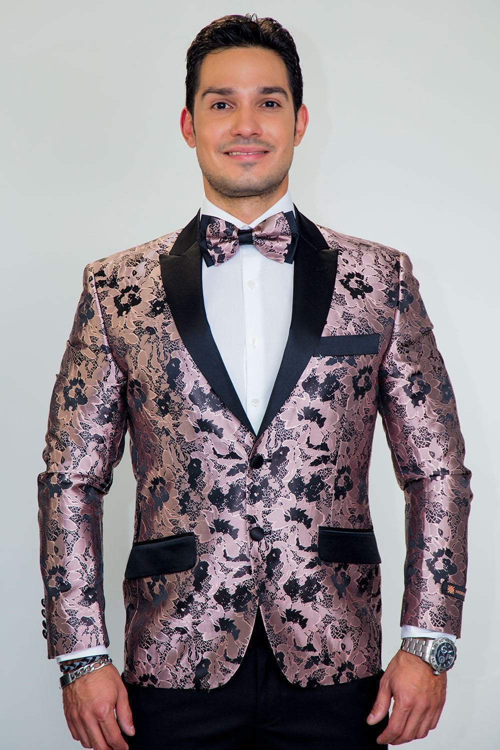 Amsterdam Tuxedo Jacket Peak in pink floral metallic fabric with black peak lapels, worn with white shirt and bow tie.