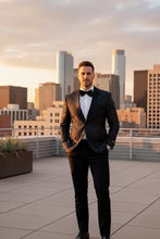 Amsterdam Tuxedo Jacket Peak worn by a man in a black suit with peak lapels against a rooftop city skyline.
