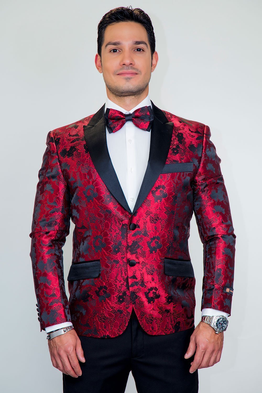 Male model wearing Amsterdam Tuxedo Jacket Peak in red-black floral pattern with peak lapels and bow tie.